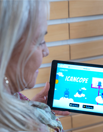 Dr. Jennifer Stinson looks at a tablet showing iCanCope