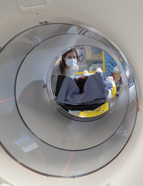 Medical staff preparing a child for a PET scan