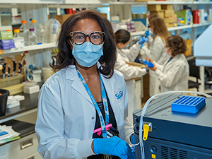 Dr. Glenda Courtney-Martin Dr. Glenda Courtney-Martin works in her lab with her research team in the background.