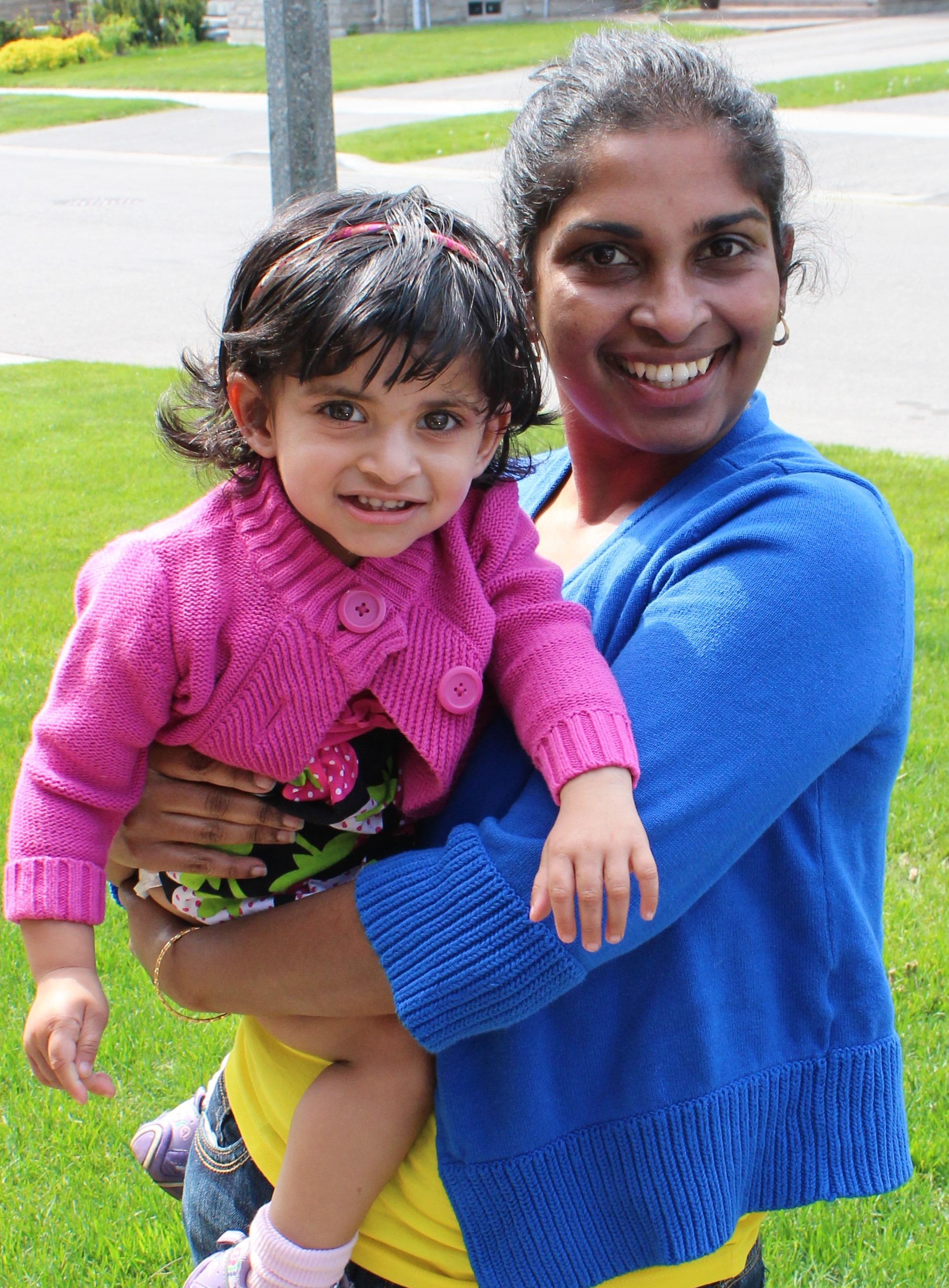 A woman holding her toddler outdoors