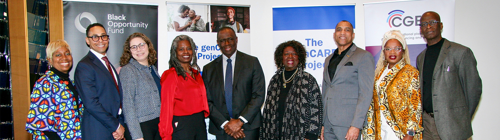 A group of people stand infront of banners at the genCARE project launch at SickKids