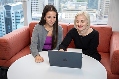 Dr. Angie Lim working on a laptop with a colleague