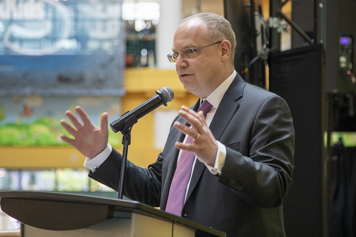 Ronald Cohn speaking at a podium