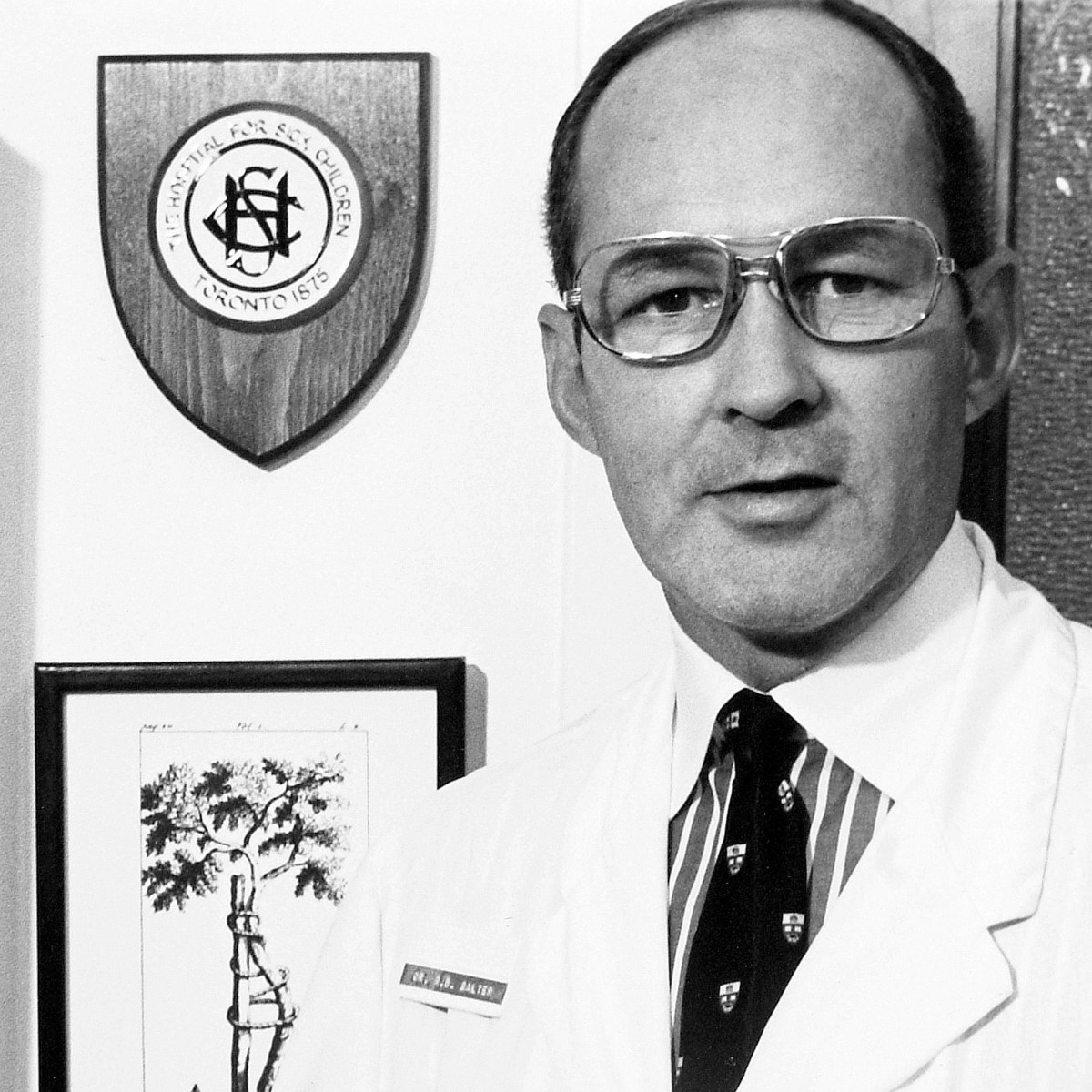 Portrait photograph of Dr. Robert Salter in a white lab coat with glasses.