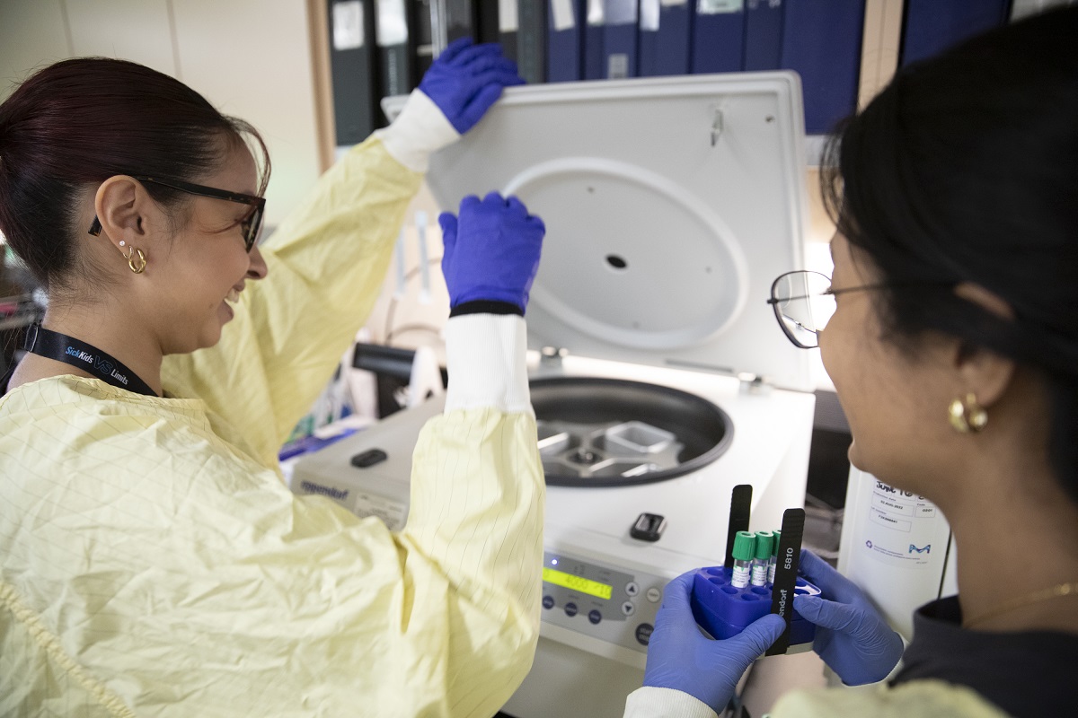Two people use lab equipment.