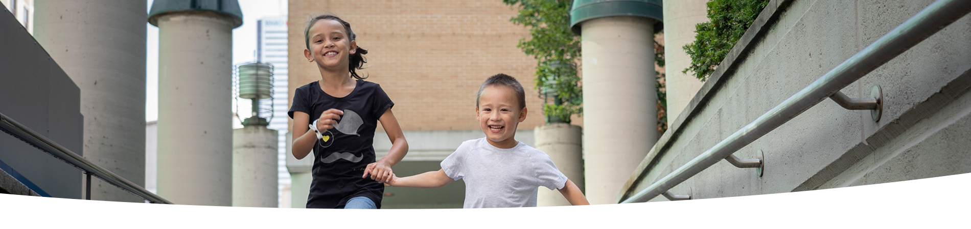 Children run holding hands outside SickKids