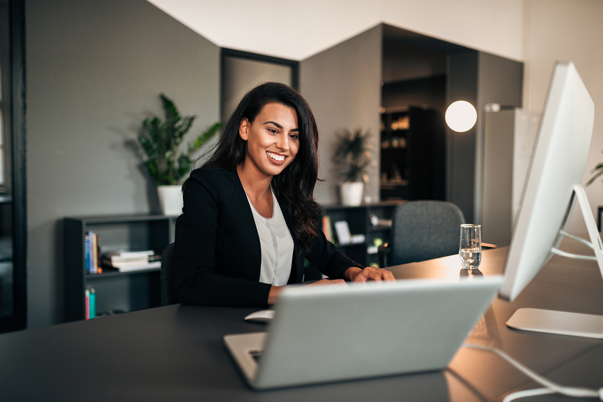 Woman seated at a desk with a computer.