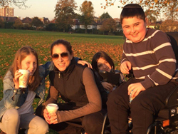 Four people sit together, arms around one another.
