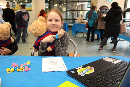 A young girl hugging a teddy bear