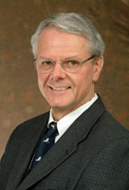 Headshot of a man wearing a suit.