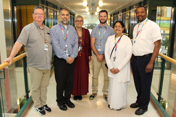 Group of six staff stand together.