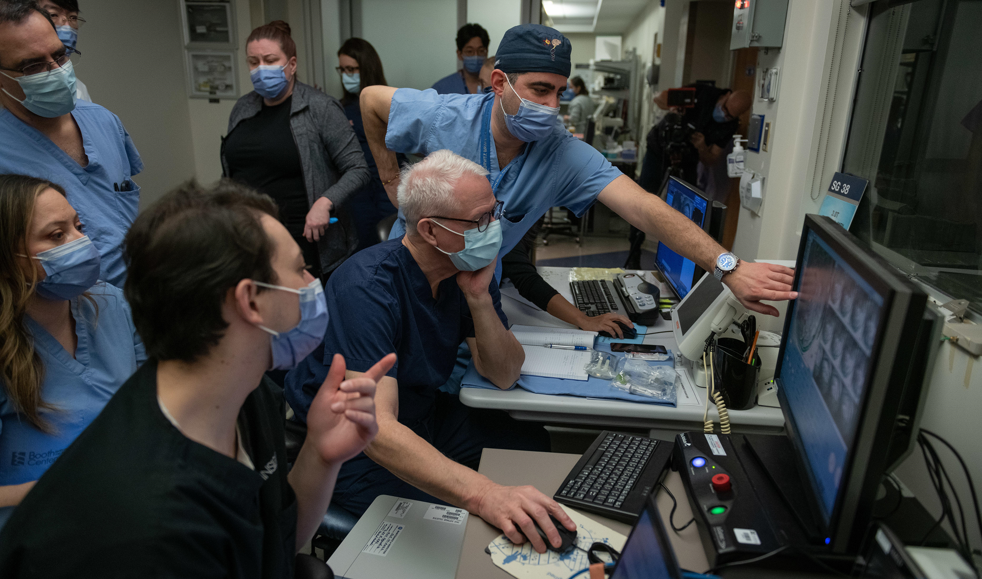 Team in the control room. Drs. Lipsman and Rutka looking at screens. 
