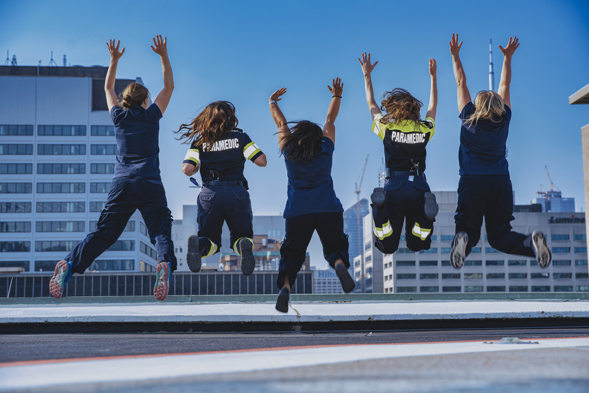 ACTS team members jumping in the air in unison on top of the SickKids helipad.