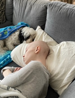 Alexandra sleeping on her couch with her dog