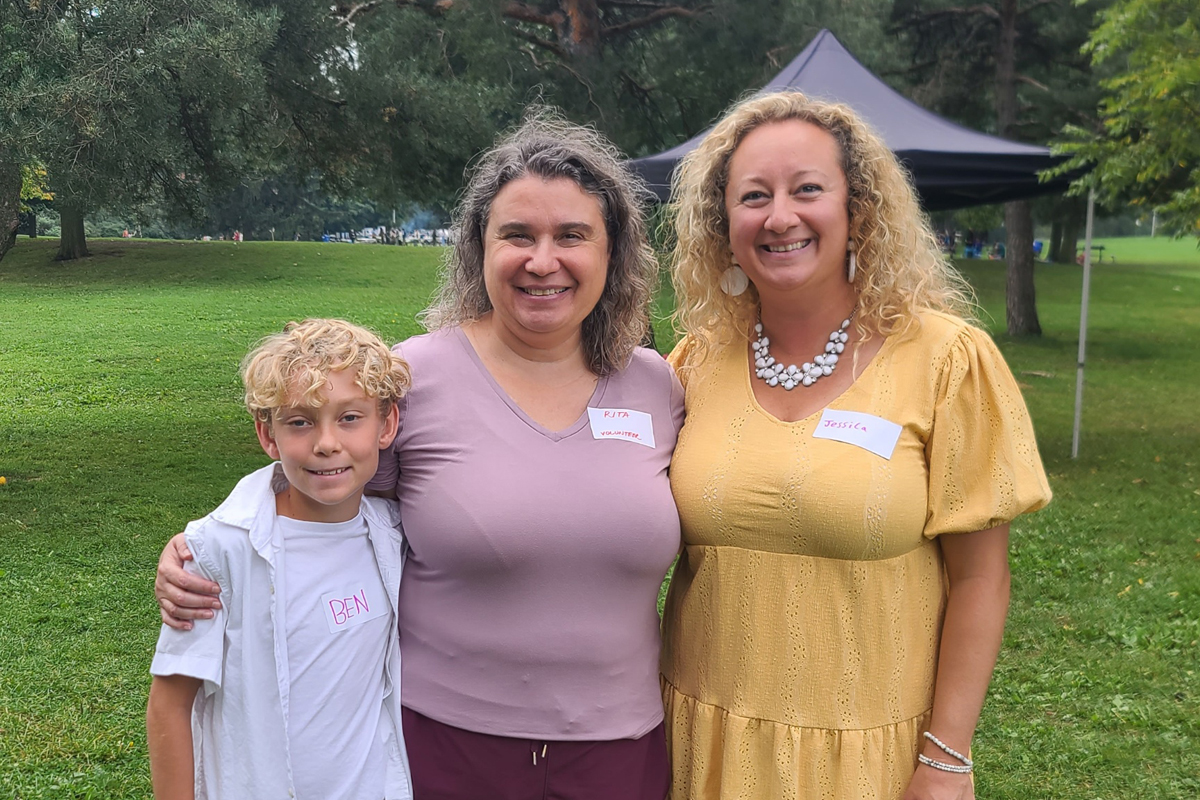 Ben, Rita and Jessica pose for a picture in a park at the 2024 NICU barbecue.