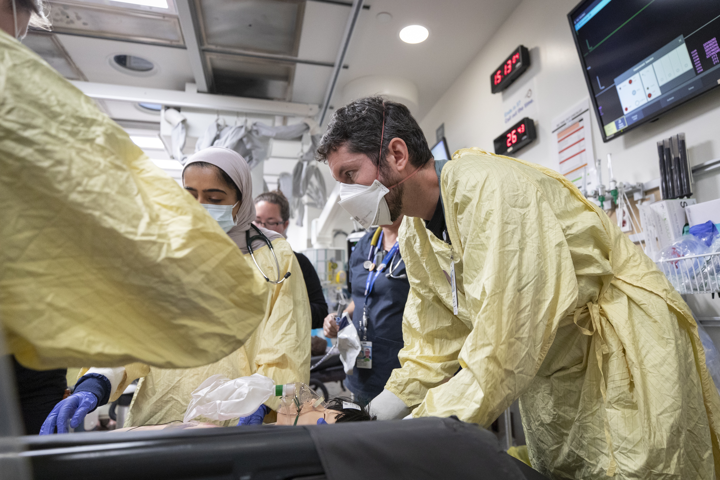 A care team member stabilizes a simulated patient in the trauma room.  
