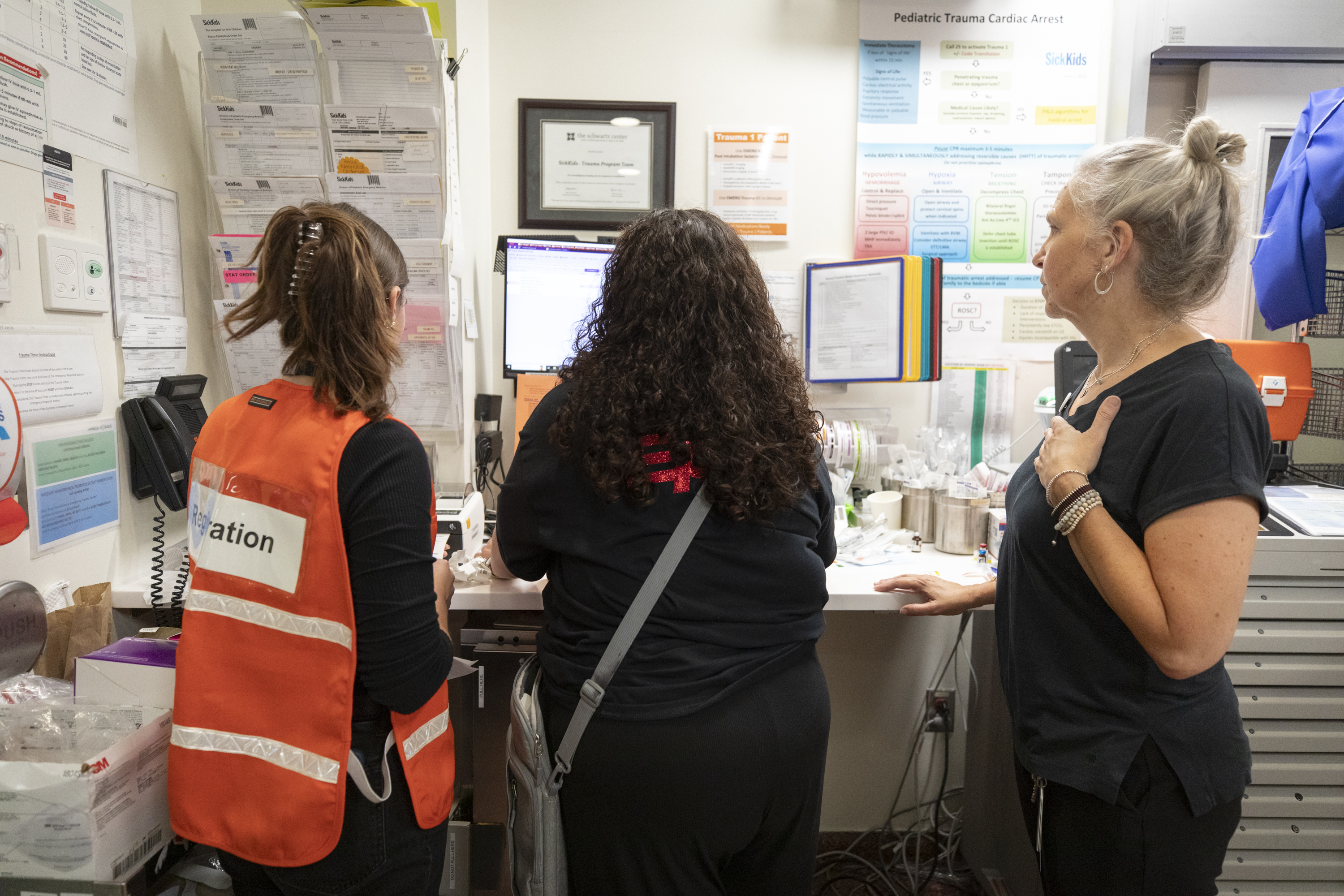Andrea Boysen, right, and other staff work at a computer station to register simulated patients as they arrive. 
