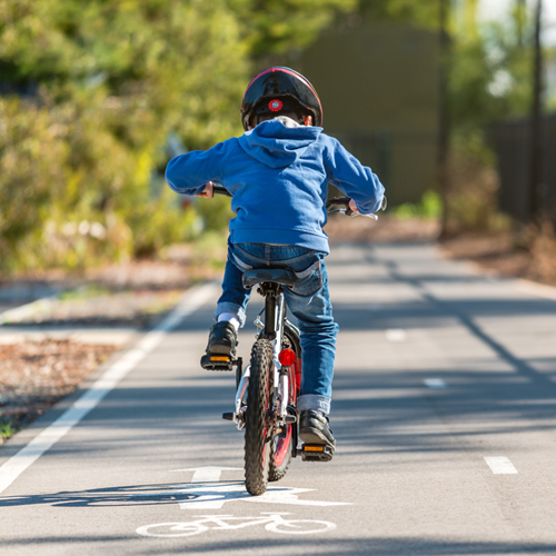 A young child riding a bike in a bike lane.