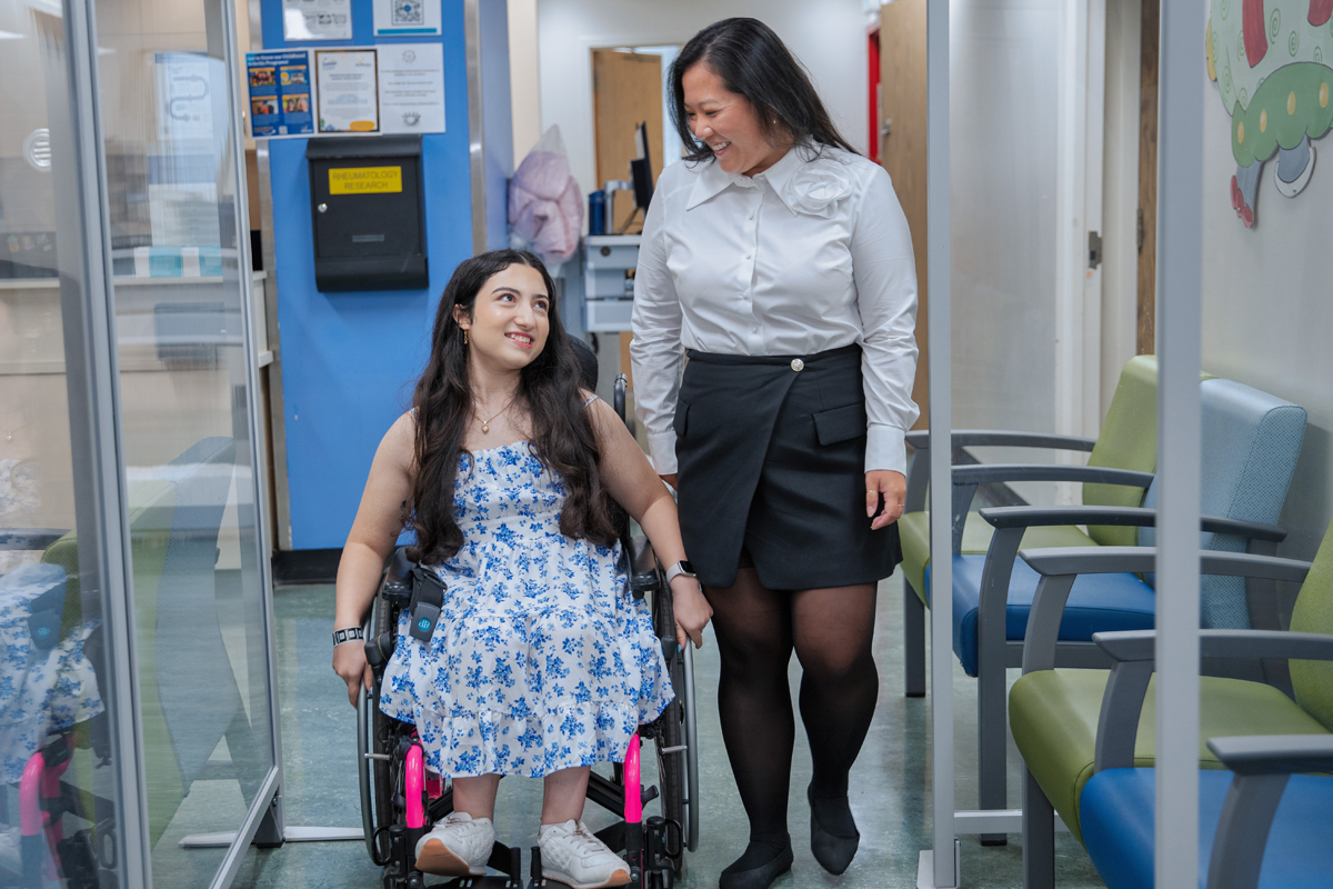 Melika and Anna smiling and strolling down a clinic hallway