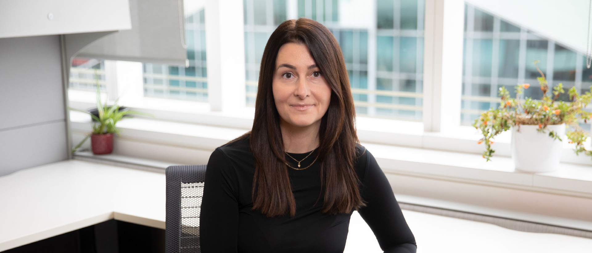 Tanya Papaz smiling for a photo. She is seated in an office.