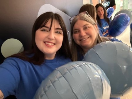 Kat and Liv hold blue balloons in a selfie.