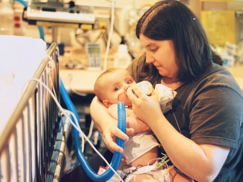 Kat using a bottle to feed Liv in hospital.