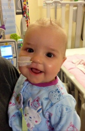 Leah being held in the hospital, with a smile on her face.