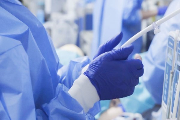 Close up photo of gloved hands and scrubs