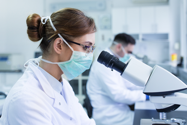Scientist looking into a microscope