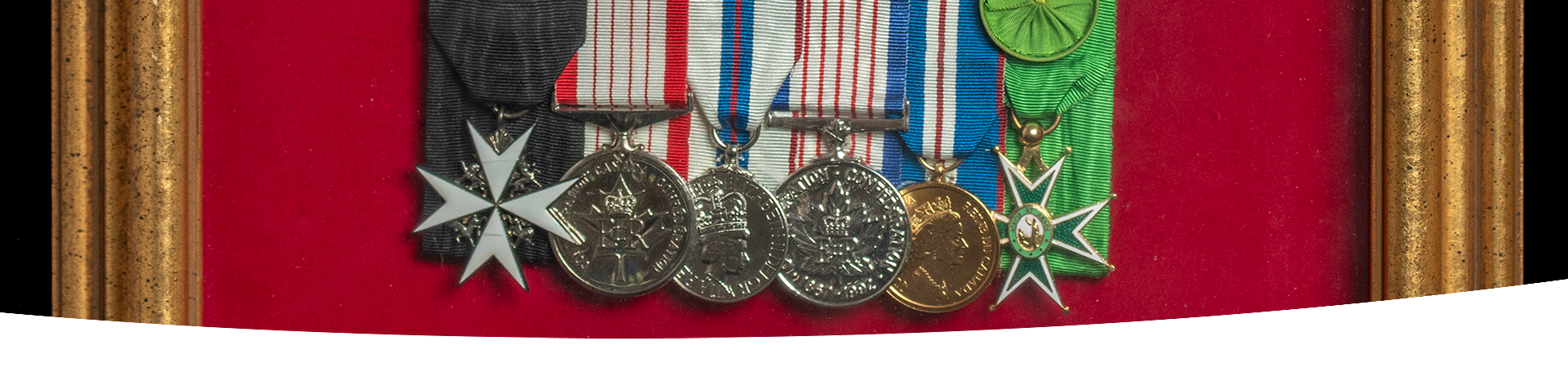 A close-up of a set of medals displayed in a picture frame.